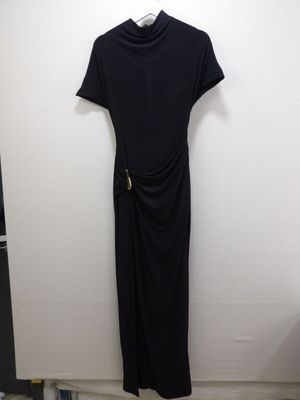 a black dress hanging on a white wall in a room