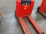two red forklifts sitting in a warehouse