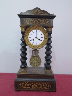 une horloge posée sur une table recouverte d'une nappe rose