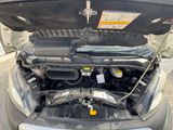 the engine of a car with its hood open in a parking lot