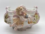 a figurine of a cupid playing a trumpet