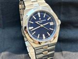 a close up of a watch with a blue face on a metal bracelet