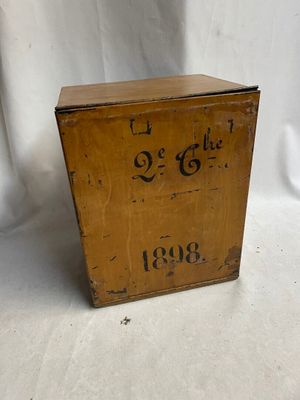 une vieille boîte en bois posée sur une surface blanche