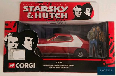 a red and white toy car with a man standing next to it
