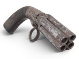 an old gun that is sitting on a white surface