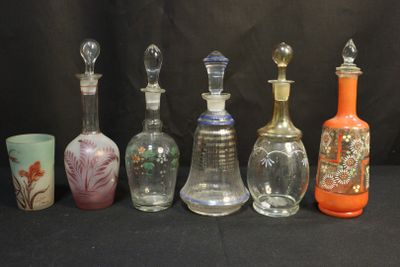 Plusieurs bouteilles en verre aux motifs variés sont alignées sur un fond noir.