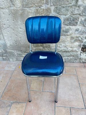 a blue chair that is sitting on a tile floor