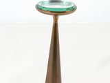 une petite assiette en verre vert posée sur un socle en or