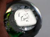 a close up of a person ' s hand holding a glass object with a heart on it