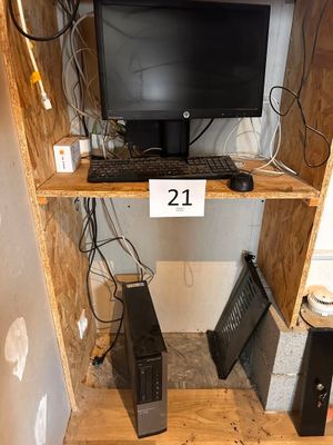 a computer desk with a monitor, keyboard, mouse, and speakers