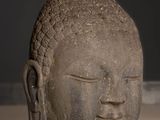 statue of a head of a buddha on a white surface
