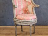 une chaise sur laquelle est posé un coussin rayé rose et blanc