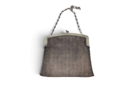 une photo d'un sac à main suspendu à une chaîne sur un mur blanc