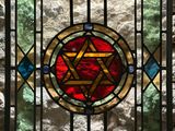 a close up of a stained glass window with a star of david on it