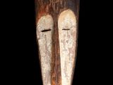 une image d'un masque en bois sur fond noir
