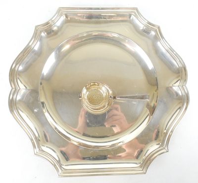 une personne en train de prendre une photo dans un miroir d'une assiette en argent