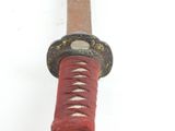 a close up of a red and black samurai sword on a white background