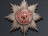 an image of a silver and red star badge on a black surface