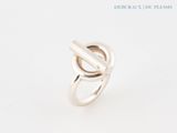 a close up of a silver ring on a white surface