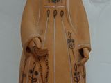a ceramic statue of a woman wearing a hat and holding a cane