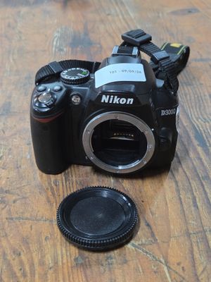 a camera sitting on a wooden table with a lens in front of it