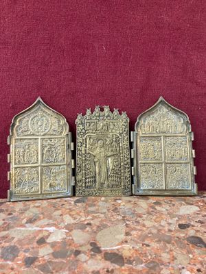 three antique brass plaques on a table with a red background