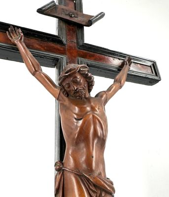 une statue en bronze représentant Jésus sur une croix, posée sur une table
