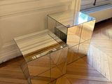 une table en verre sur laquelle est posé un miroir, dans un coin de la pièce