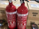 two fire extinguisors sitting next to each other on a table