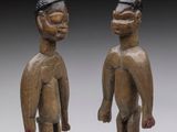 two carved wooden figures of a man and a woman