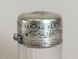 a small glass jar with a silver lid on a table