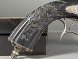 an old gun with a metal handle sitting on top of a wooden box
