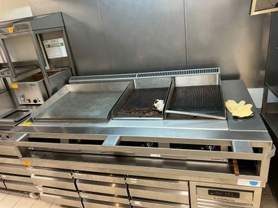 une grande cuisine professionnelle dotée de nombreux plans de travail en inox