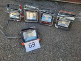 cinq projecteurs posés au sol à côté d'un panneau