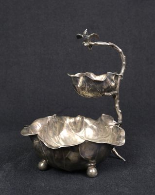 une assiette en argent antique avec un oiseau sur le dessus