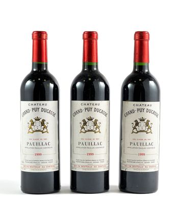trois bouteilles de vin rouge posées l'une à côté de l'autre sur une surface blanche