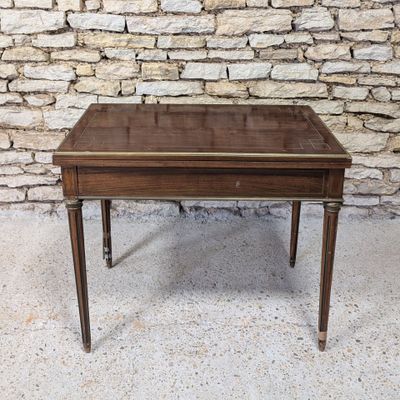 a wooden table with a glass top sitting on top of a cement floor