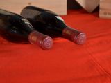 two bottles of wine sitting on a red table cloth