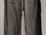 un pantalon gris suspendu à un cintre devant une porte blanche
