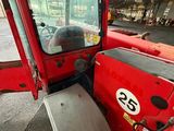 a red tractor that is parked in a garage