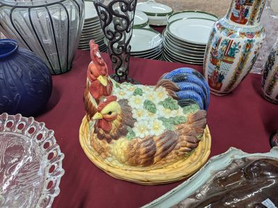 a cake on a plate on a table with plates and vases