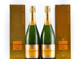 deux bouteilles de champagne devant un coffret doré