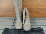 une paire de bottes grises posée sur un sac noir