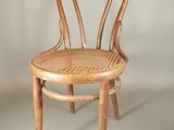 a wooden chair with a wicker seat on a white background