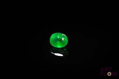a close up of a green jade stone on a black surface