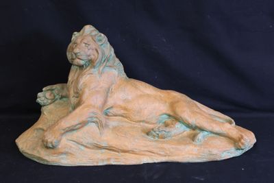 sculpture of a lion laying down on a black background