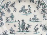 a blue and white plate with birds and flowers on it