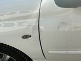 a white car with a hole in the side of it