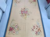 un tapis posé au sol sur lequel est représenté un bouquet de fleurs