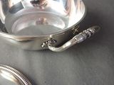 a silver bowl and a silver spoon on a table